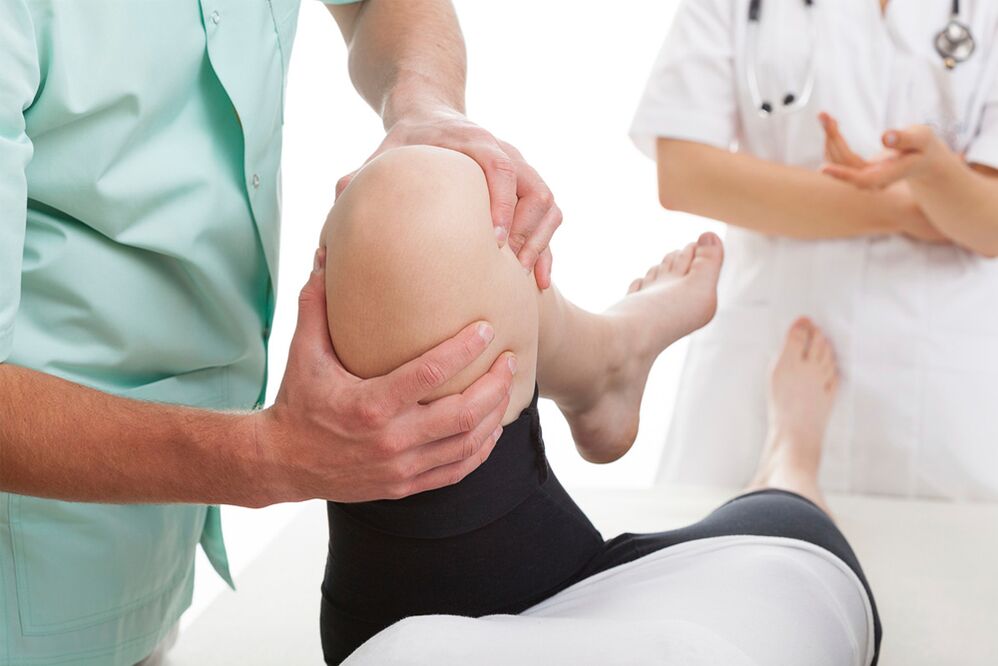 medico che esamina il ginocchio per dolori articolari